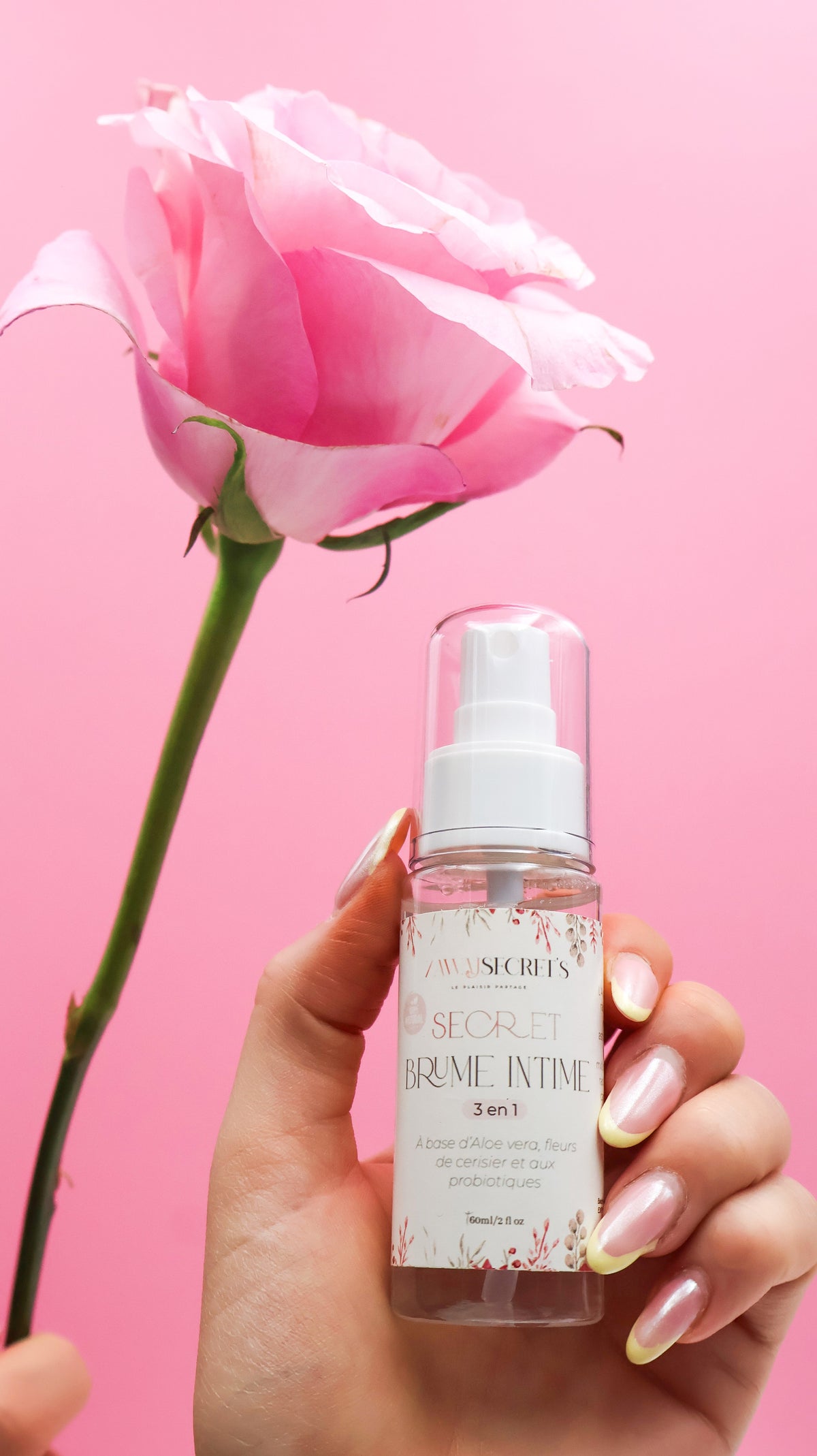 Brume intime 3 en 1 en flacon pompe, tenue en main, avec fleur rose