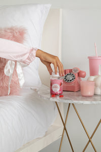 Gummies probiotiques : flacon rouge posé sur table près d’un téléphone rose.