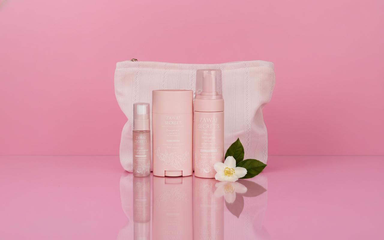 Pack Les Essentielles : 3 flacons et une bouteille rose pâle, sur trousse blanche