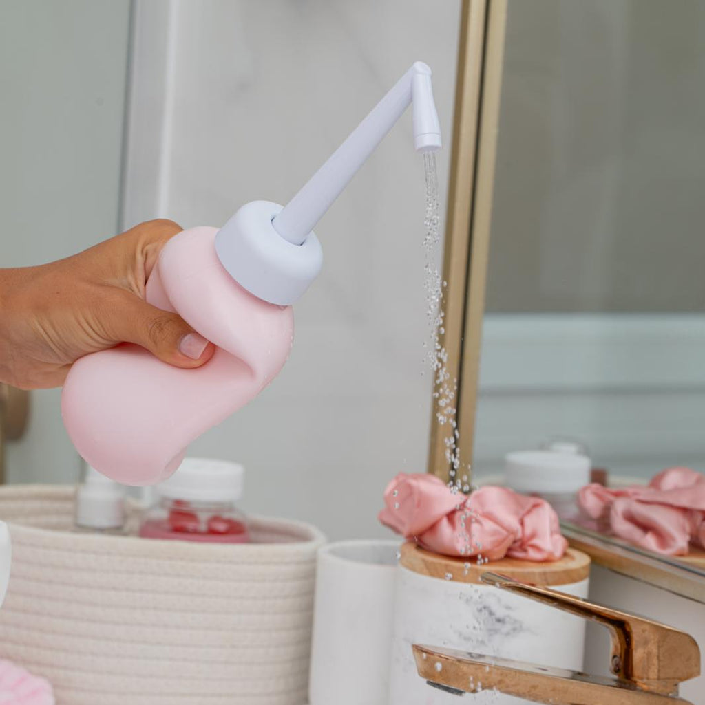 Douchette du kit Glow and Go en main, jet d’eau sur la peau