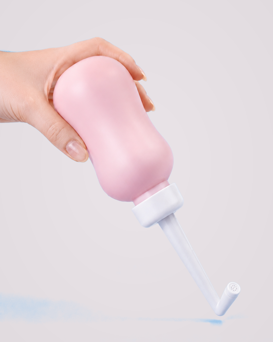 Douchette nomade intime — produit réel sur fond gris perle rosé