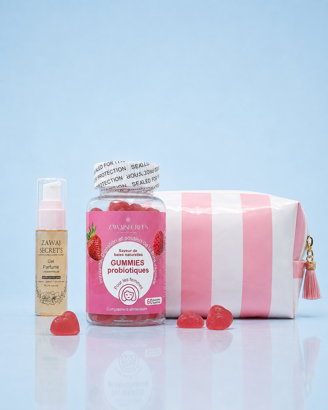 Flora Glow — gel parfumé petit format, gummies probiotiques en cœur et trousse rose rayée sur fond bleu ciel