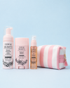 Zawaj Secret's — trio Les Essentielles et trousse rayée sur fond bleu ciel